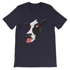 May include: A navy blue t-shirt featuring a graphic of a cow's face with its tongue sticking out. The cow has black and white markings and red eyes.