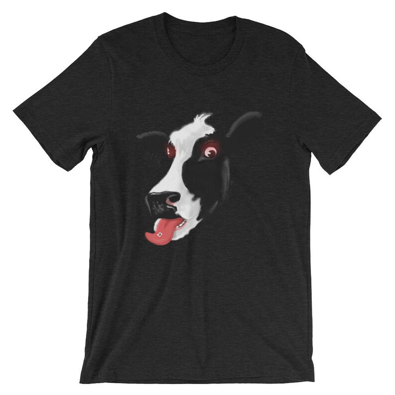 May include: A black t-shirt featuring a graphic of a cow's face with red eyes and a pink tongue sticking out.