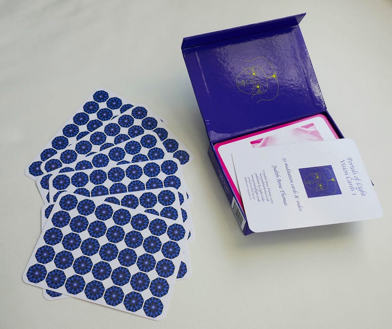 May include: A deck of 33 meditation cards and an index card in a blue box. The cards have a blue and white geometric pattern. The box has the title "Portals of Light Vision Cards 1" and the author "Judith Stone & Thomas".