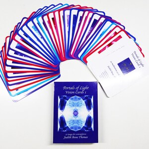 May include: A deck of 33 meditation cards called "Portals of Light Vision Cards 1" by Judith Anne Thomas. The cards are arranged in a fan shape with blue, red and white borders. The box for the cards is blue with a white image of a portal of light.