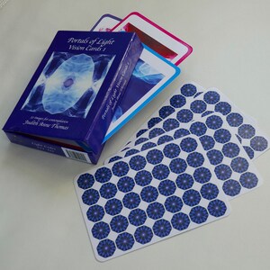 May include: A blue box with the title "Portals of Light Vision Cards 1" and the author "Judith Anne Thomas". The box contains a deck of cards with a blue and white geometric pattern.