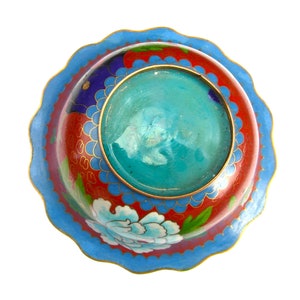 May include: A round, blue and red cloisonn&eacute; bowl with a scalloped rim. The bowl has a floral design and a turquoise centre.