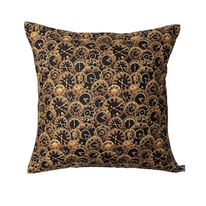 Può includere: Cuscino nero con un motivo a orologio dorato. Il cuscino è realizzato in un tessuto morbido e confortevole e ha una cerniera.