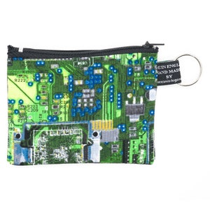 May include: A small green zippered pouch with a circuit board pattern. The pouch has a black zipper and a silver key ring. The text on the pouch reads "EIN ENGL HAND MAD BY oceania-legen".