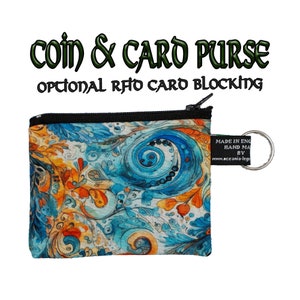 Könnte beinhalten: Eine kleine, blau-orangefarbene Münz- und Kartenbörse mit Reißverschluss und Schlüsselring. Die Börse trägt den Text "COIN & CARD PURSE" und "OPTIONAL RFID CARD BLOCKING". Die Börse ist in England hergestellt und handgefertigt.