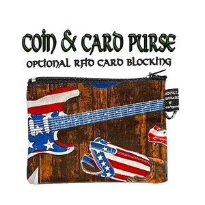 May include: A small coin and card purse with a zipper closure. The purse is made of fabric with a woodgrain background and a design of an American flag electric guitar and a boot. The text "coin & card purse" and "optional RFID card blocking" is printed on the image.
