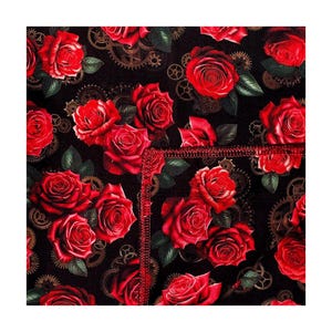 May include: A black fabric featuring a repeating pattern of vibrant red roses and intricate bronze-colored mechanical gears. The material displays a visible red stitched seam running vertically and horizontally across the center of the floral design.