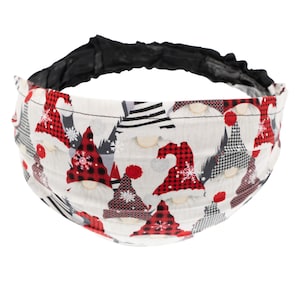 May include: A white headband with a black elastic band. The headband is decorated with a pattern of gnomes wearing red and white hats with black and white accents.