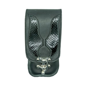 Può includere: Custodia per telefono in pelle nera con design a pelle di serpente e chiusura argentata.