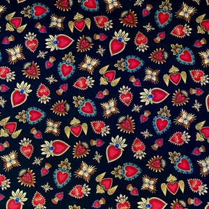 May include: A black fabric with a repeating pattern of red, gold and green stylised hearts. The hearts are surrounded by gold rays and some have gold wings.