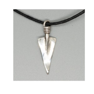 May include: Silver arrowhead pendant necklace with a black cord. The arrowhead is a simple, triangular shape with a rounded top.