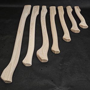 Puede incluir: Ocho mangos de hacha de madera sin terminar de diferentes longitudes. Los mangos son de color marrón claro y tienen un acabado natural liso.