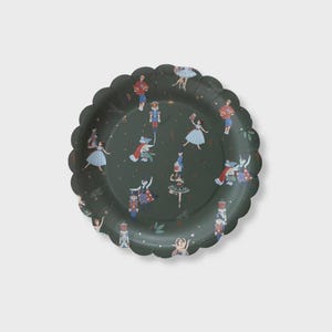 May include: A dark green paper plate with a scalloped edge. The plate is decorated with illustrations of ballet dancers, nutcrackers, and other festive figures. The design is in shades of red, blue, white, and gold.