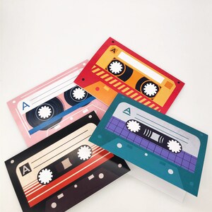 May include: Four colorful cassette tape cards with the letter "A" on each card. The cards are stacked on top of each other.
