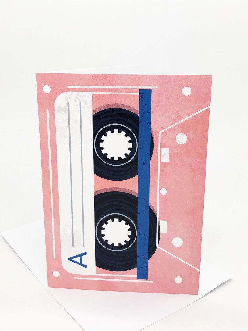 May include: A pink cassette tape with a blue stripe and black spools. The tape is labeled with the letter "A".