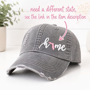 May include: Distressed gray baseball cap with the word "home" and a pink outline of the state of Florida. The cap has a curved brim and a worn, vintage look. The text "need a different state, see the link in the item description" is above the cap.