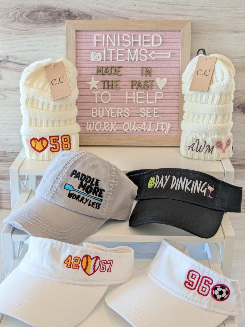 a collection of hats and caps with various embroidered designs, including numbers and text, arranged on a shelf.
