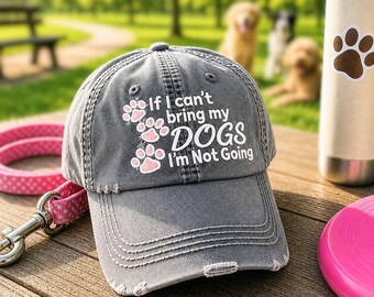 May include: A charcoal gray baseball cap with distressed edges featuring white text that reads If I can't bring my DOGS I'm Not Going, accompanied by three light pink paw print graphics embroidered on the front panel of the hat.