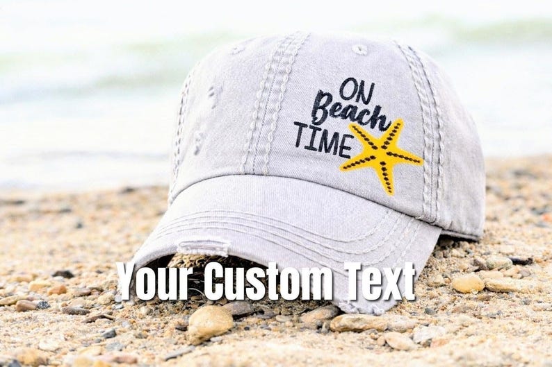 May include: A light gray distressed baseball cap with the text "ON Beach TIME" and a yellow starfish graphic. The cap also features the text "Your Custom Text" across the front.