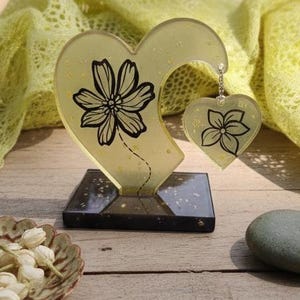 Transparente gelbe Harzherz-Skulptur mit schwarzer Blume – Einzigartiges Grafikobjekt – Boho-Solardekoration – Originelles Geschenk für Frauen