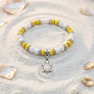Damenarmband aus mattem Onyx und gelbem Kristall mit einem silbernen Schildkrötenanhänger