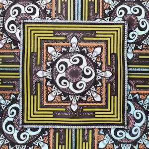 Peut inclure: Écusson de tissu carré avec un motif géométrique. Le patch présente un motif central en forme de mandala en blanc, marron et orange, entouré d'un cadre carré avec des lignes jaunes et marron. Le tissu de fond a un motif répétitif de formes similaires.