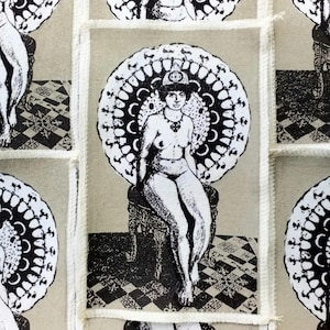 May include: A repeating pattern of rectangular patches featuring a black and white illustration of a seated figure with a decorative halo. The figure is nude and seated on a detailed chair. The background is a light tan color.