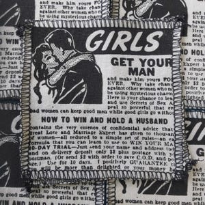 Peut inclure: Carré de tissu noir et blanc avec texte et illustrations. Le texte dit "GIRLS GET YOUR MAN" et "HOW TO WIN AND HOLD A HUSBAND". L'image présente un couple s'embrassant et du texte ressemblant à une publicité vintage.