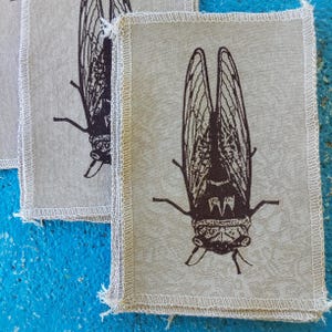 Ręcznie robiona naszywka z nadrukiem sitodrukowym „Cykada”: aplikacja na koszulkę z recyklingu