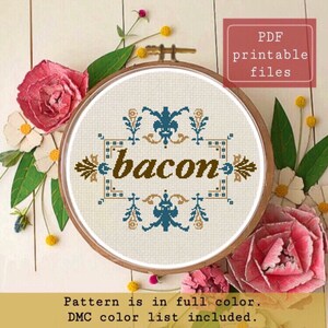 Può includere: Uno schema di ricamo a punto croce con la parola "bacon" in un carattere marrone con un bordo decorativo. Lo schema è in un cerchio e circondato da fiori. Il testo "File PDF stampabili" è in una casella bianca con un bordo nero.