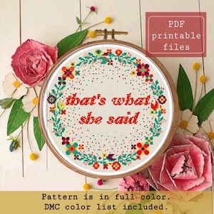 Può includere: Schema di punto croce con una ghirlanda di fiori e la frase "that's what she said" in lettere rosse. Lo schema è a colori e include un elenco di colori DMC.