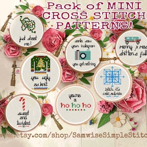 Puede incluir: Un paquete de 10 mini patrones de punto de cruz con frases divertidas de temática navideña. Los patrones se muestran en aros de bordado blancos con una variedad de hilos de bordar de colores. Los aros están rodeados de flores rosas.