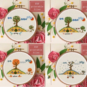 May include: Four embroidery patterns for cross stitch featuring a house with a round door and a tree in different seasons. The seasons are spring, summer, autumn, and winter. Each pattern is in a hoop and labeled with the season.