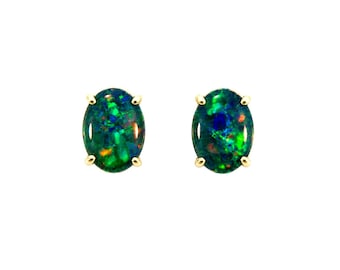 Puede incluir: Un par de pendientes de botón con forma ovalada que presentan ópalos de color verde oscuro con destellos vibrantes de azul, rojo y amarillo. Cada gema está sujeta de forma segura en un engaste de cuatro garras de oro amarillo pulido.