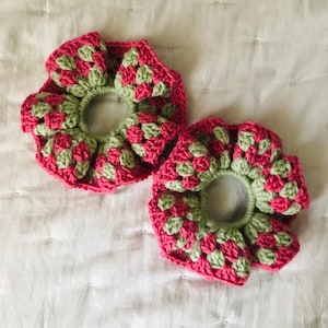 Puede incluir: Dos coleteros de ganchillo hechos a mano, rosas y verdes. Los coleteros están elaborados con un patrón de granny square, lo que les da un aspecto vintage. Estos accesorios para el cabello son ideales para añadir un toque de color a cualquier peinado.
