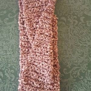 Op de afbeelding: Een mauve gebreid hoofdband met een zachte, pluche textuur.