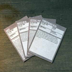 May include: Four cards with text on them, each card has a title, casting time, components, range, and duration. The titles are "Gate", "Mass Heal", "Astral Projection", and "Power Word Heal".