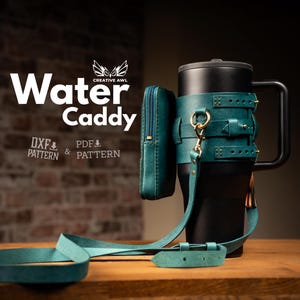 May include: A black water bottle with a teal leather water caddy, a small pouch, and a shoulder strap. The caddy has gold-colored hardware and is designed to hold the bottle securely. The words "Water Caddy" are displayed in white.
