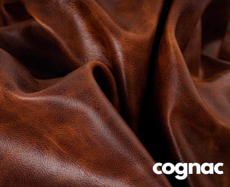 May include: Close-up of a rich brown leather with a textured surface. The leather has a warm, cognac color.