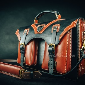 May include: A handcrafted leather briefcase in black and brown with white stitching. The bag features two front pockets, a top handle, and a detachable shoulder strap. Gold-colored hardware accents the design.