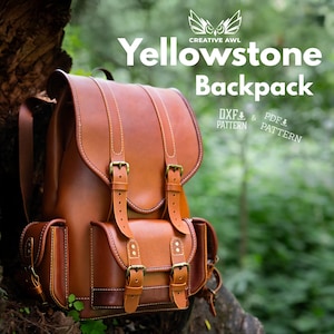 Puede incluir: Una mochila de cuero color canela con una solapa grande, dos correas verticales con hebillas y tres bolsillos frontales. El texto dice Creative Awl Yellowstone Backpack, DXF Pattern y PDF Pattern. Incluye costuras visibles y hebillas metálicas.