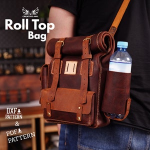 May include: A brown leather roll-top bag with a water bottle holder. The bag has a roll-top closure, multiple pockets, and adjustable straps. The bag is worn over the shoulder. The text "Roll Top Bag" is visible.