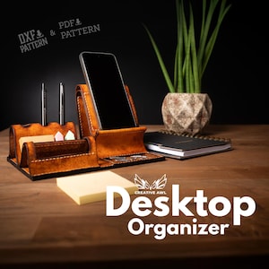 Könnte beinhalten: Ein brauner Leder-Schreibtisch-Organizer mit Handyhalter, Stifthaltern und Notizblock. Der Organizer hat auch einen kleinen Bereich für Haftnotizen. Der Text "Desktop Organizer" ist in Weiß dargestellt.
