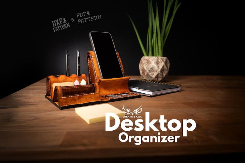 May include: A brown leather desk organizer with a phone holder, pen holders, and a notepad. The organizer also has a small section for sticky notes. The words "Desktop Organizer" are displayed in white text.