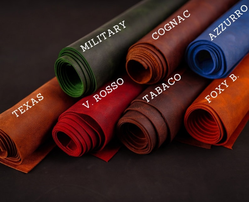 May include: Close-up of rolled leather samples in various colors, including brown, red, green, blue, and orange. The leather is labeled with names like "Texas", "V. Rosso", "Military", "Cognac", "Tabaco", "Foxy B", and "Azzurro".