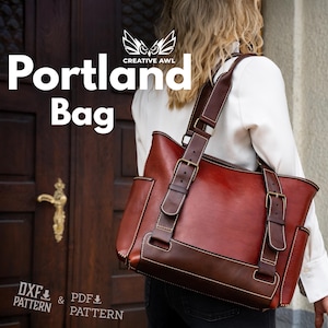 Puede incluir: Un bolso de hombro de cuero bicolor en rojo y marrón oscuro con correas ajustables con hebillas metálicas, bolsillos laterales y costuras visibles. El texto "Portland Bag" y "Creative Awl" aparece junto a "DXF Pattern & PDF Pattern".