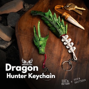 Op de afbeelding: Drie sleutelhangers met drakenmotieven en een set sleutels zijn gerangschikt op een houten oppervlak. De sleutelhangers hebben groene drakenkoppen en -doorns, met zilveren sleutelringen. De tekst "Dragon Hunter Keychain" is zichtbaar.