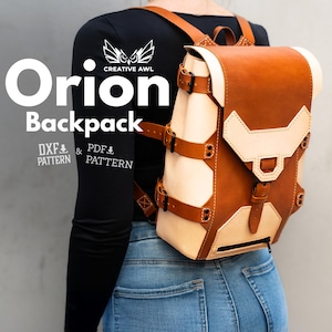 Może przedstawiać: Skórzany plecak Orion w kolorze brązowym i kremowym. Plecak ma unikalny design z klamrami i regulowanymi paskami. Tekst "Orion Backpack" jest widoczny na zdjęciu. Idealny do przenoszenia przedmiotów.