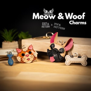 Op de afbeelding: Leren bedels met een kat, een vis, een Franse bulldog en een bot. De kat is oranje en wit, de bulldog is bruin en zwart, en het bot is wit. De tekst "Meow & Woof Charms" is zichtbaar.