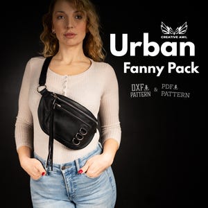 Op de afbeelding: Een zwarte leren heuptas met zilverkleurige hardware en een kwastdetail. De tas wordt over het lichaam gedragen. De tekst "Urban Fanny Pack" wordt in het wit weergegeven, samen met "DXF & PDF PATTERN".